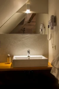 Salle de bain moderne avec lavabo et miroir.