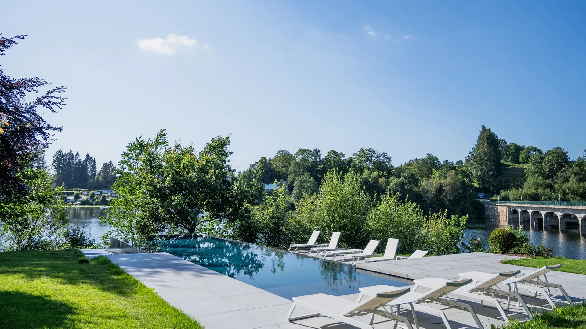 Piscine à débordement avec vue sur la rivière.