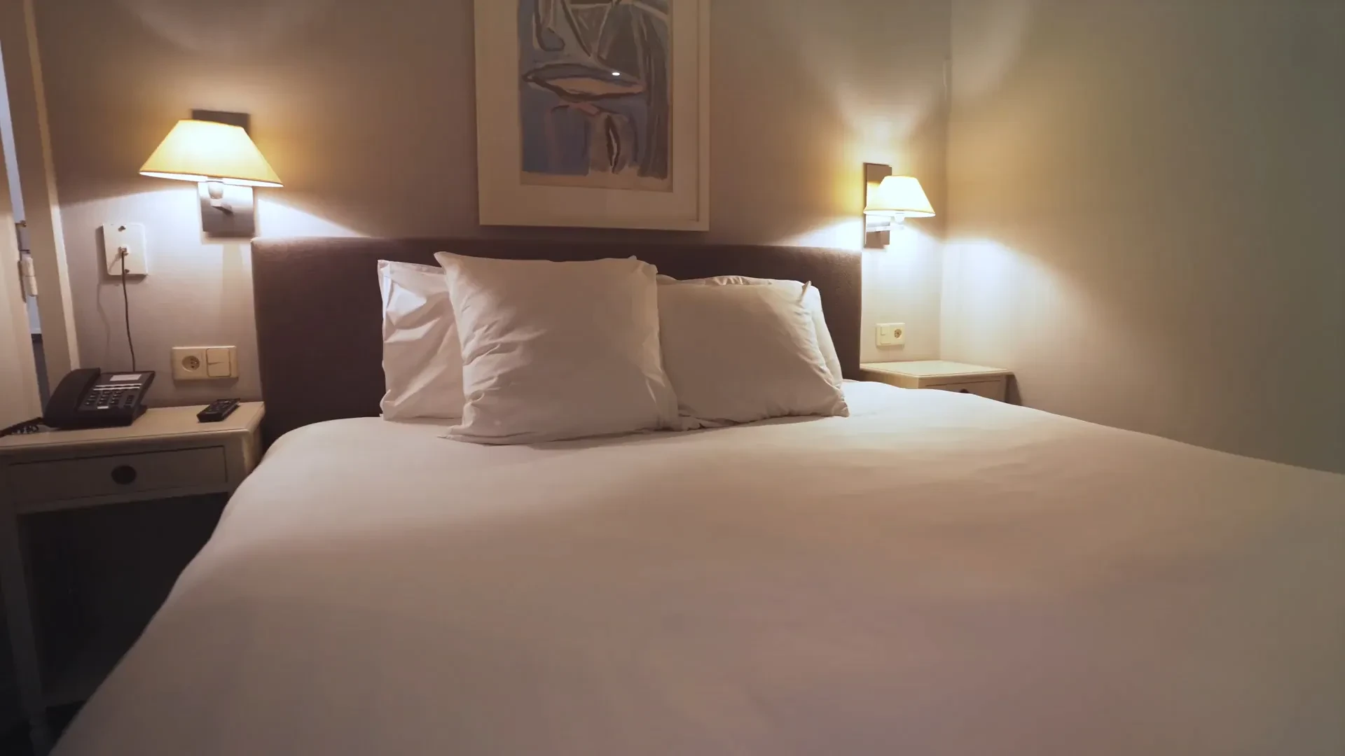 Chambre d'hôtel confortable avec lit double et lampes.