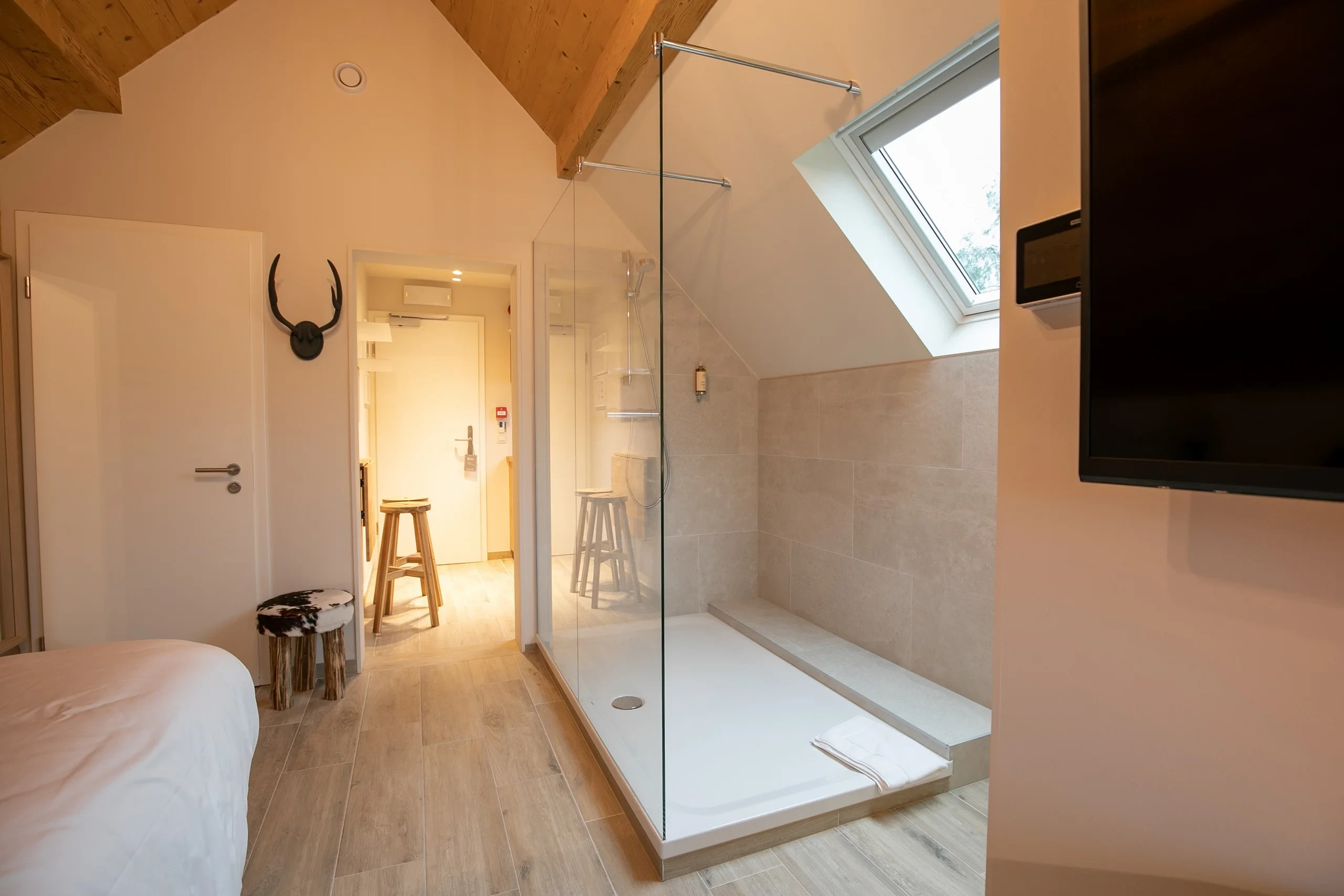 Chambre moderne avec douche et parquet en bois.