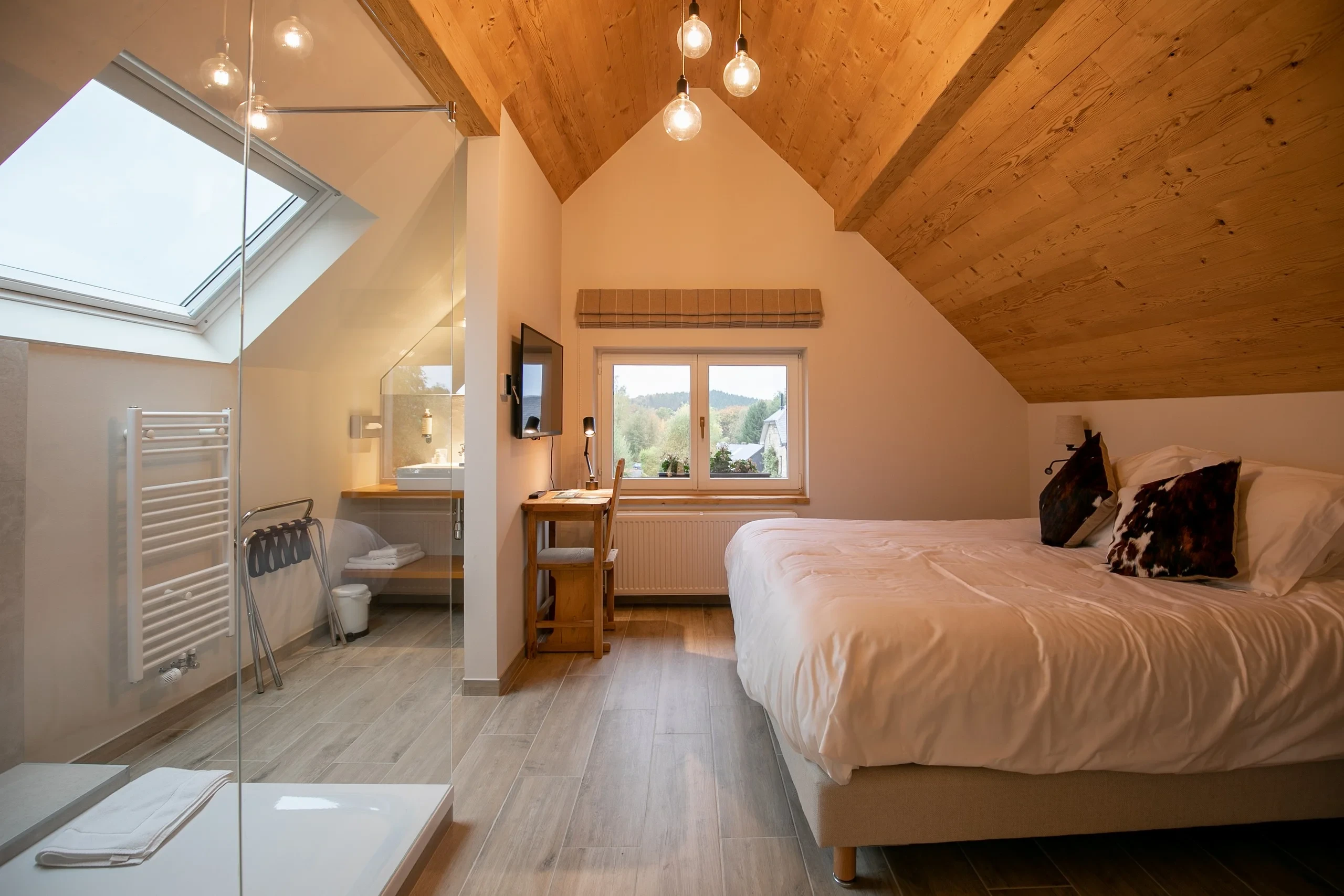 Chambre lumineuse avec plafond en bois et salle de bain