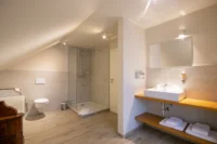 Salle de bain moderne avec douche et lavabo.