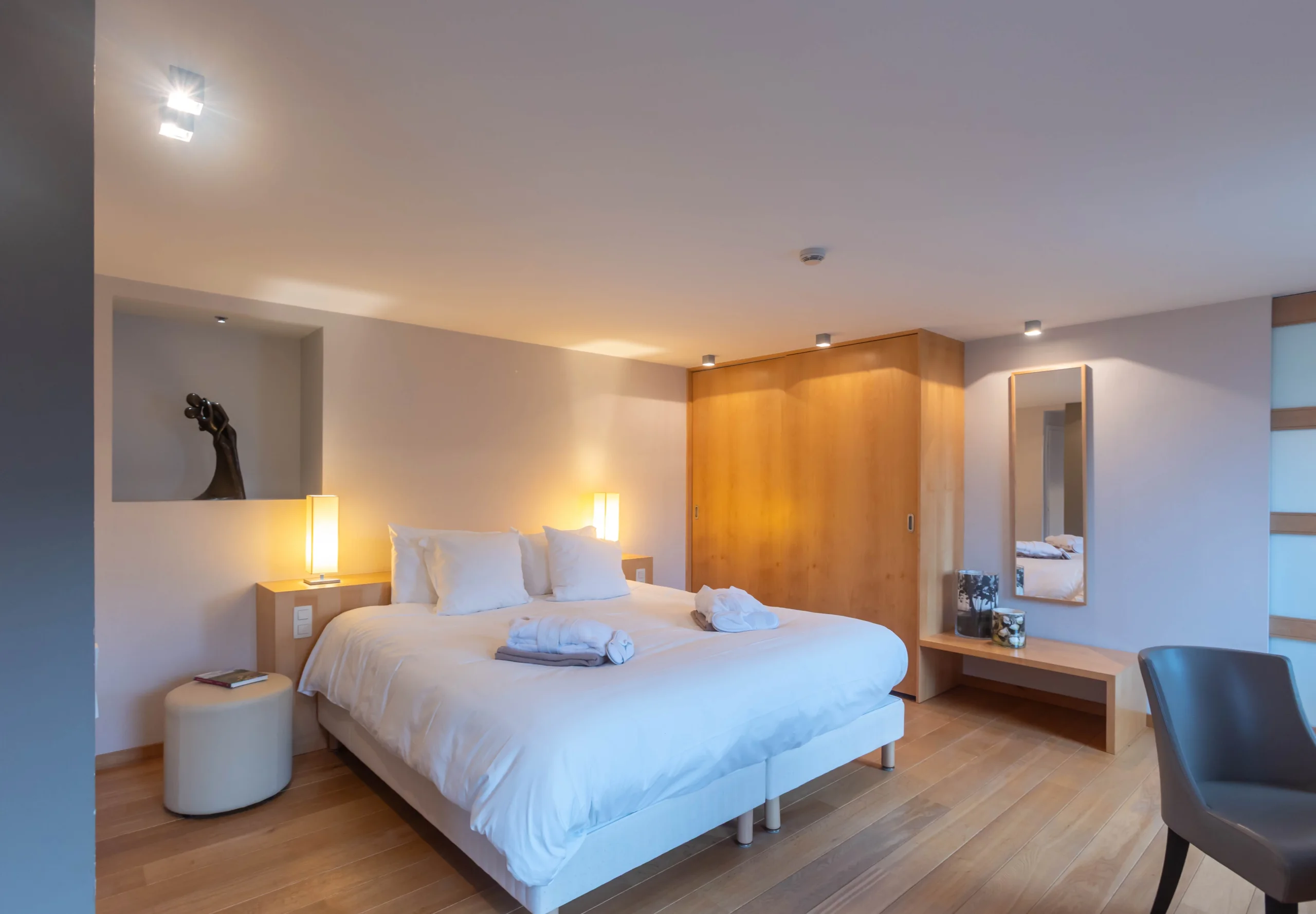 Chambre moderne avec lit double et éclairage doux.
