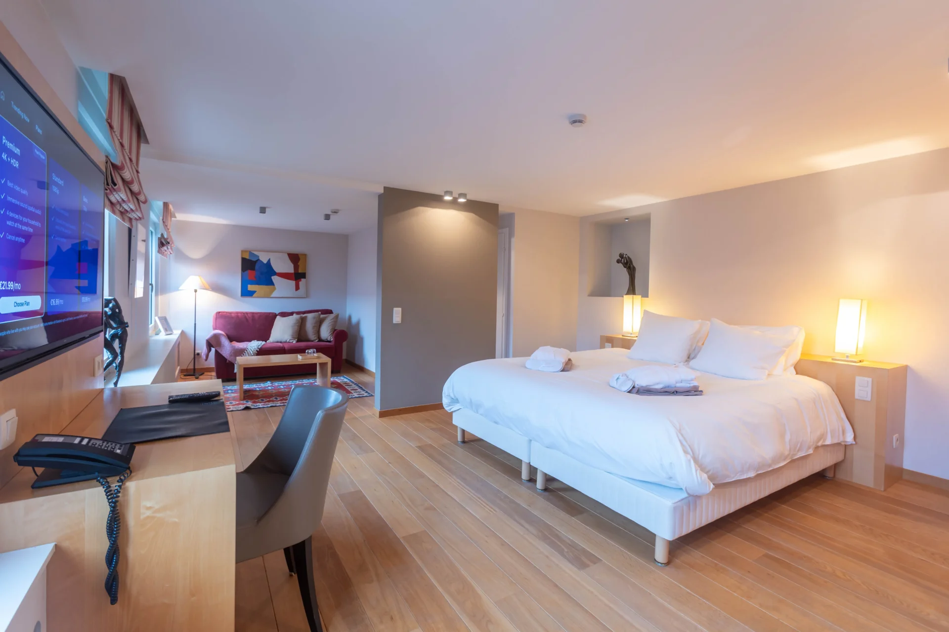 Chambre d'hôtel moderne avec lit double et bureau.