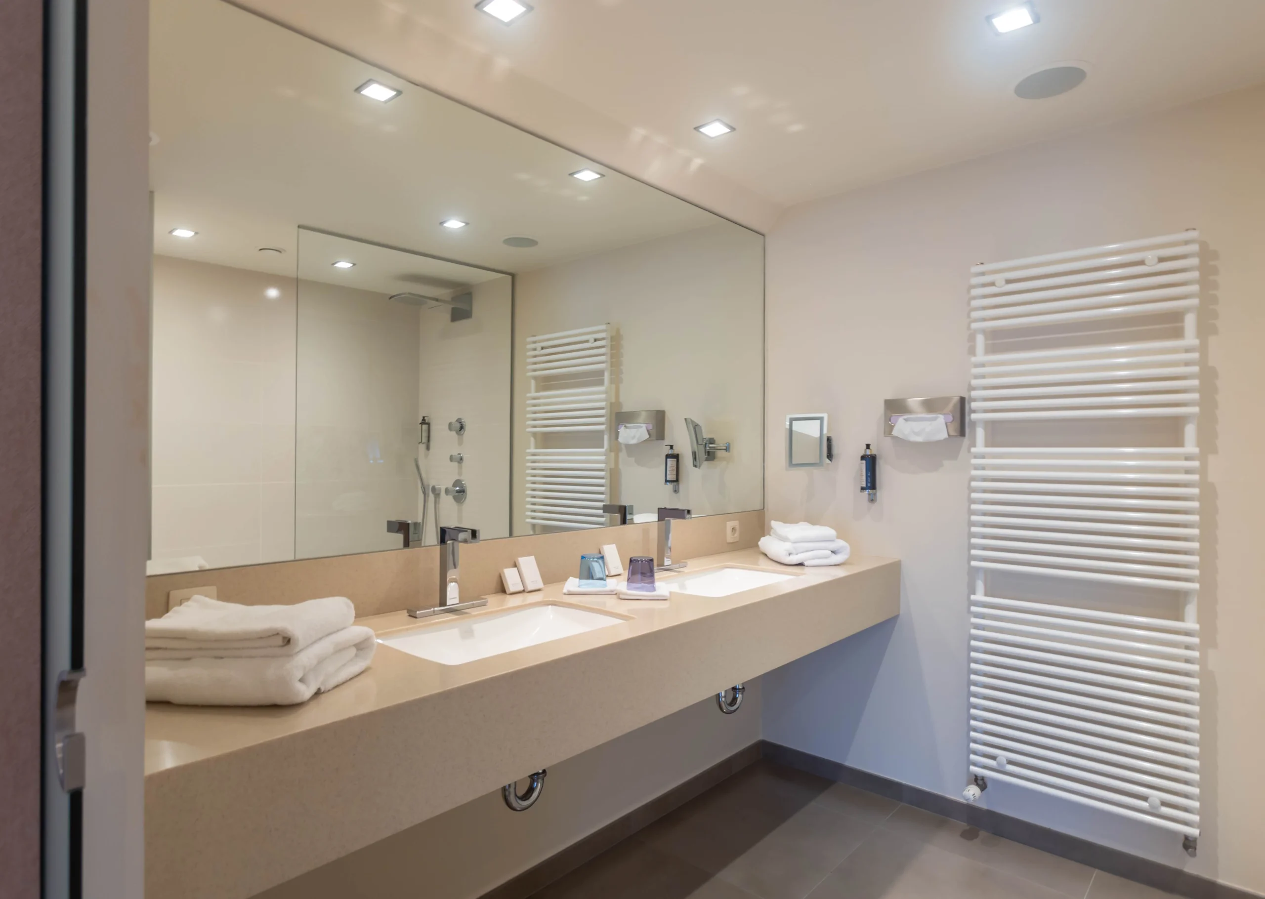 Salle de bain moderne avec double vasque et miroir.