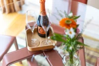 Champagne et fleurs sur table en verre.