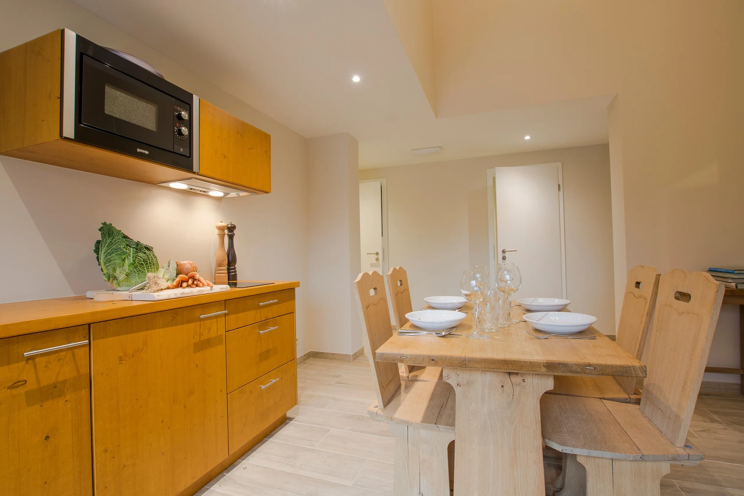 Cuisine moderne avec table en bois et ustensiles.