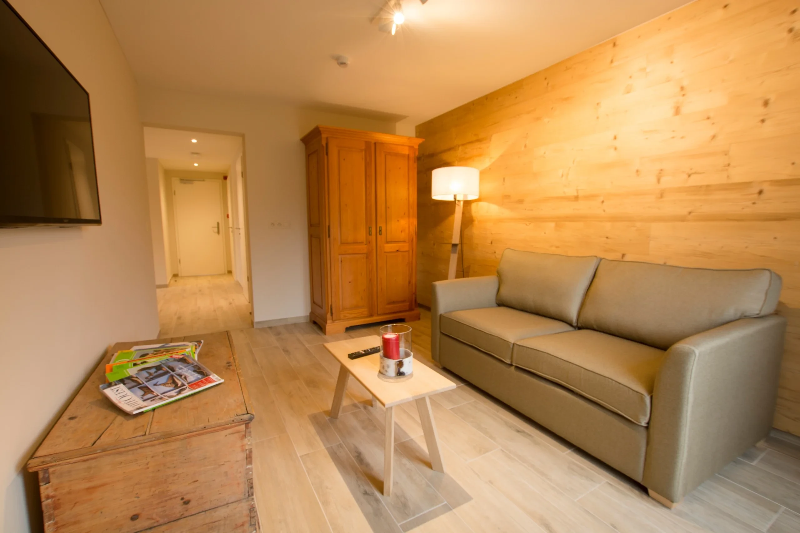 Salon moderne avec canapé et armoire en bois.