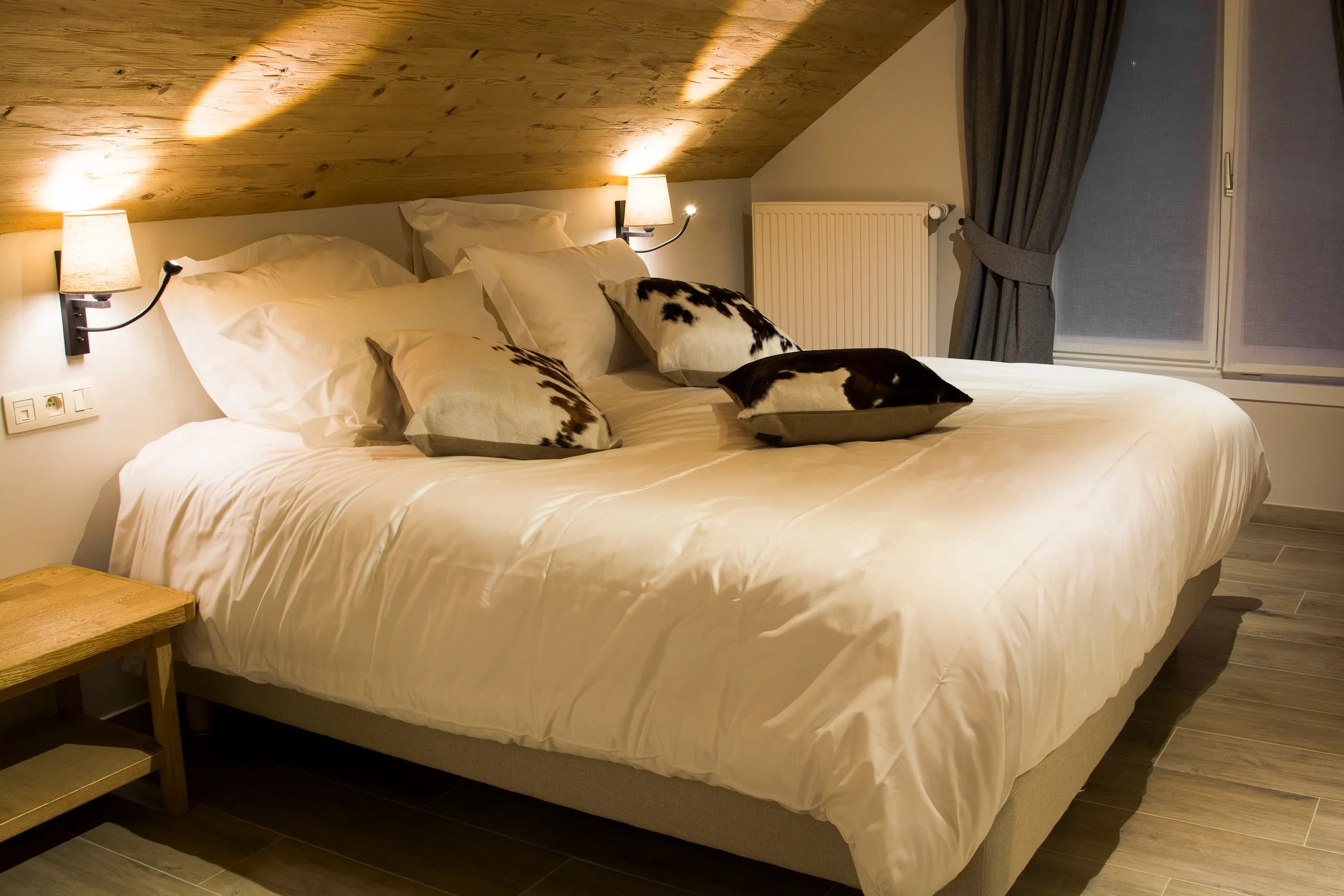 Chambre avec lit double et coussins décoratifs.
