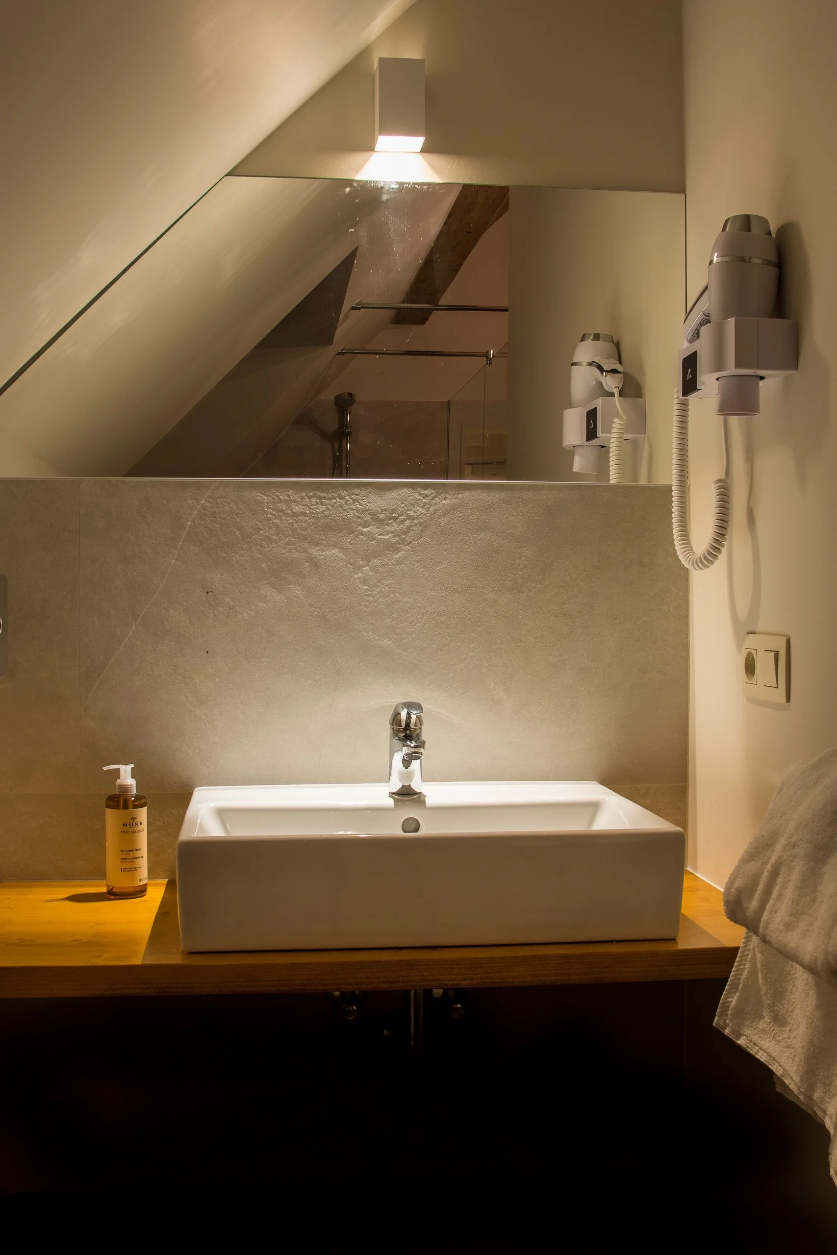 Salle de bain moderne avec vasque éclairée.