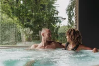 Couple relaxant dans un jacuzzi extérieur.