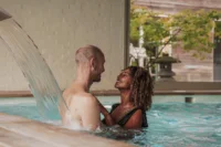 Couple souriant dans une piscine intérieure