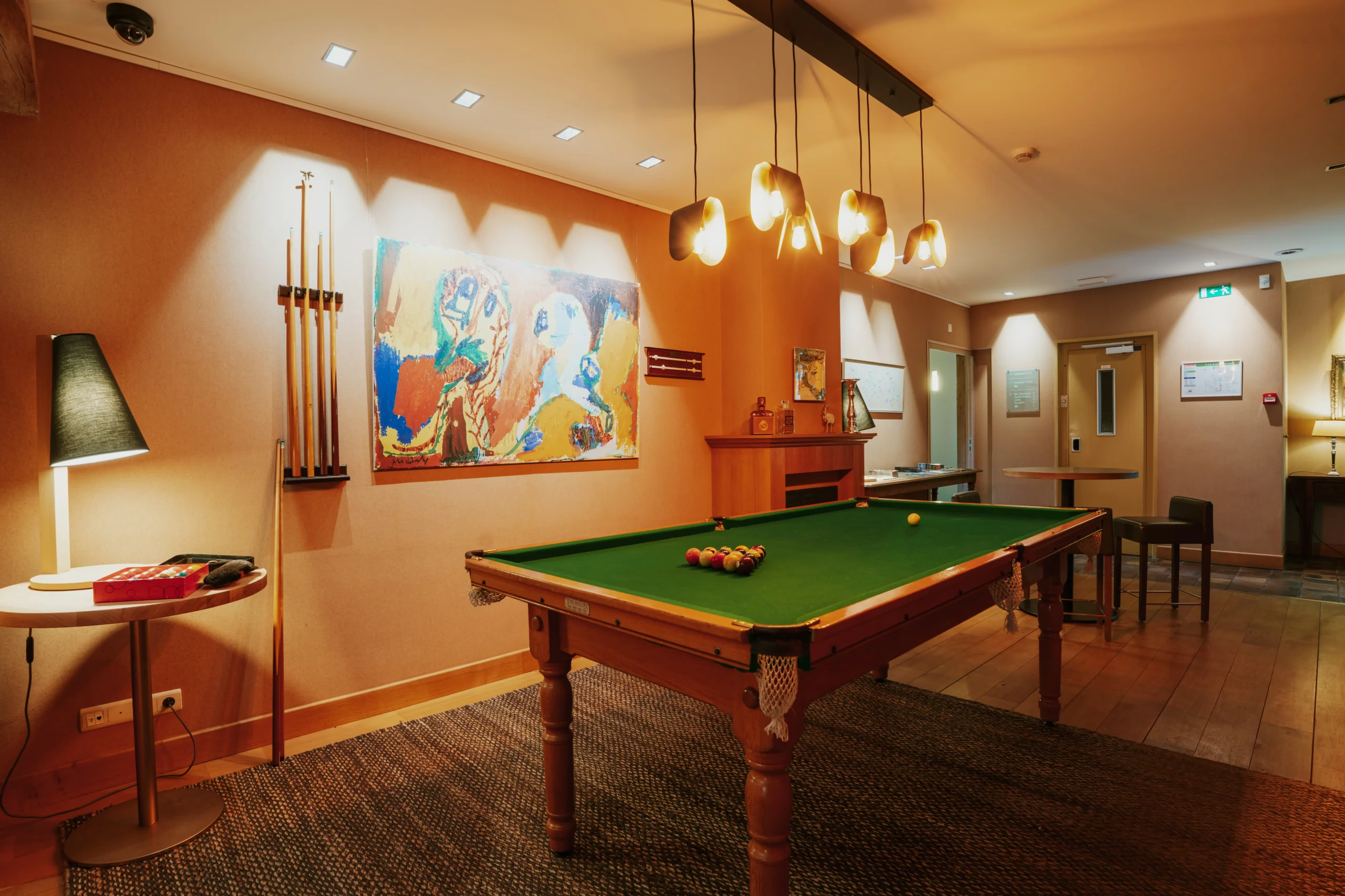 Salle de billard avec lumières et décoration artistique.