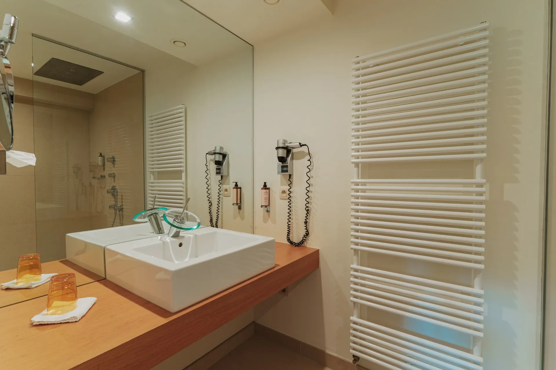 Salle de bain moderne avec miroir et lavabo.