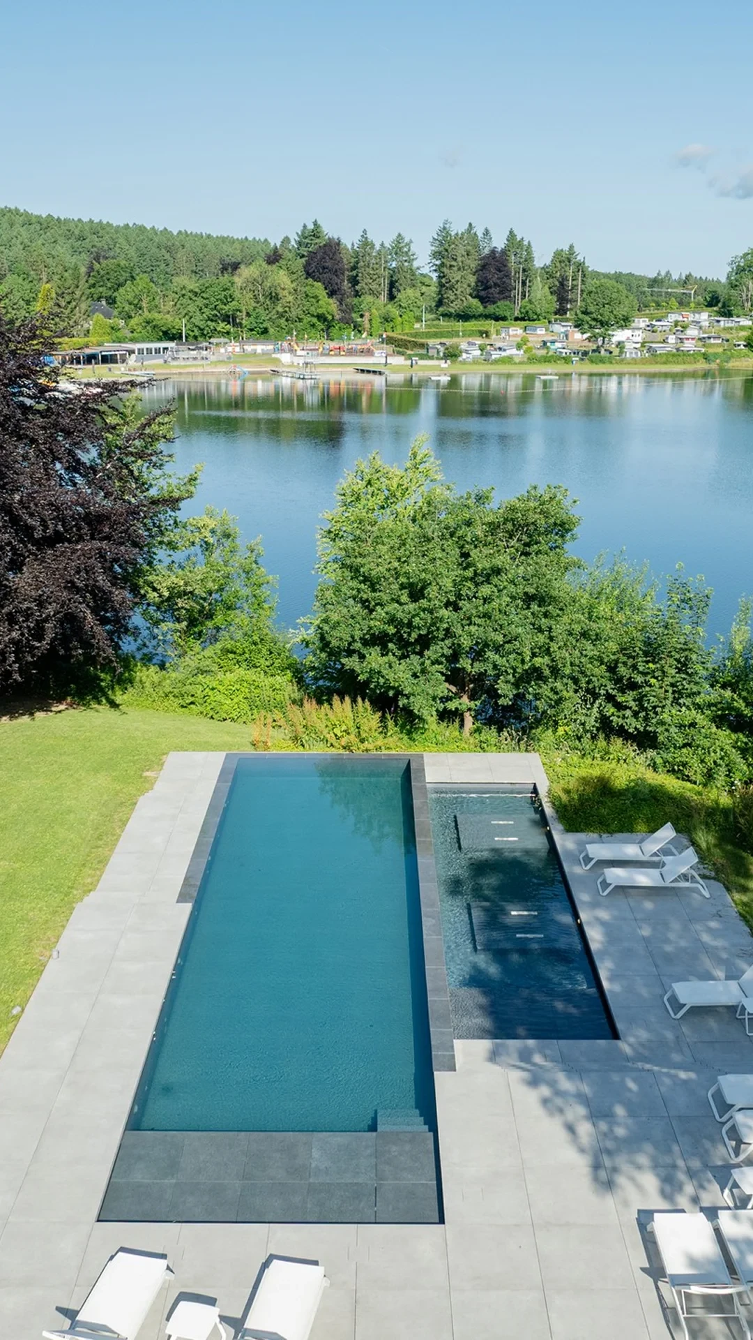 Piscine avec vue sur un lac paisible.