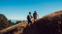 Trois randonneurs marchant au soleil couchant - Séjour Wellness Belgique - Robert Hôtels