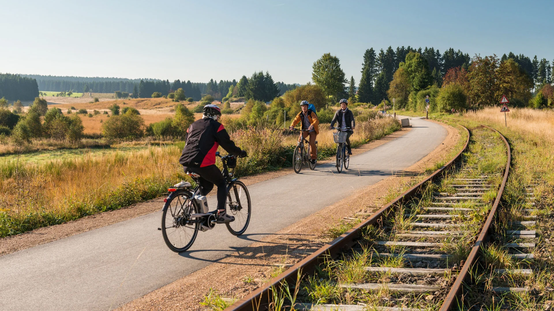 Cyclistes sur une piste près de voies ferrées abandonnées - Séjour Wellness Belgique - Robert Hôtels