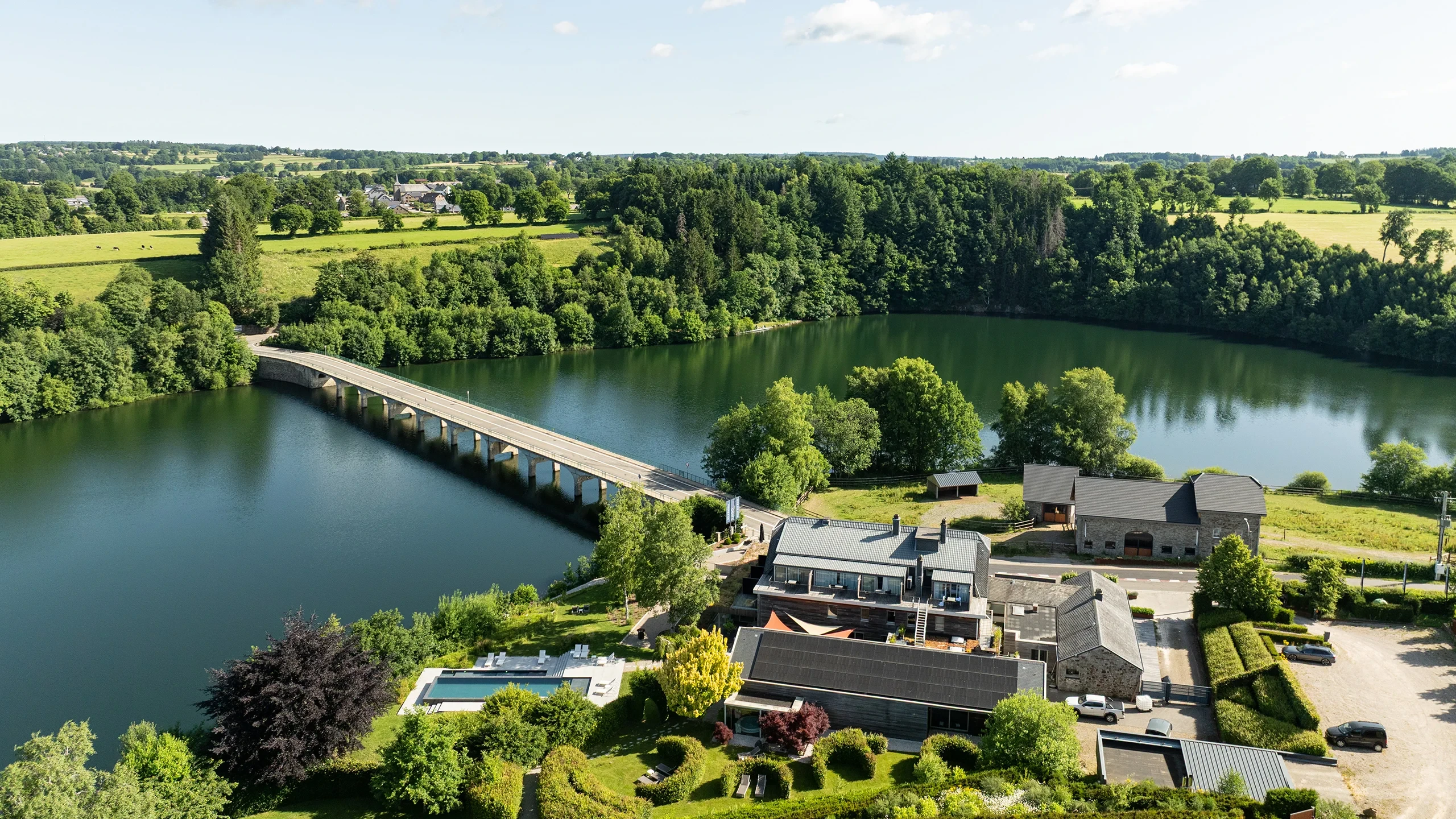 Vue aérienne d'un pont et d'un lac verdoyant.