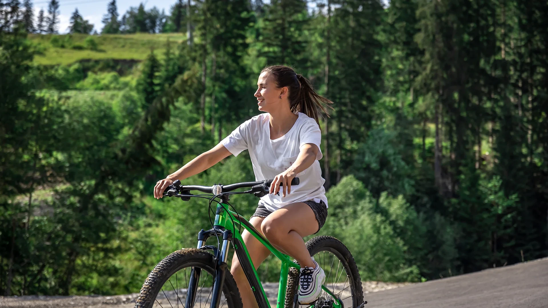 Femme faisant du vélo en forêt en été - Séjour Wellness Belgique - Robert Hôtels