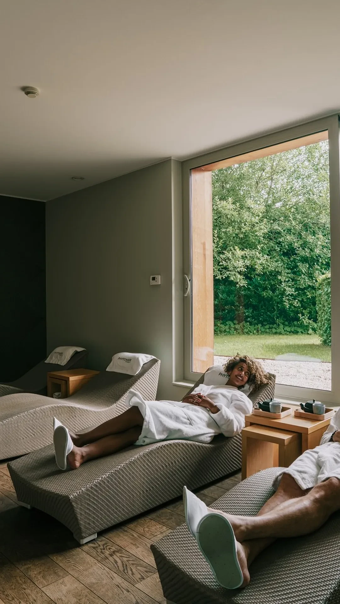 Personnes détendues dans un spa lumineux avec jardin.