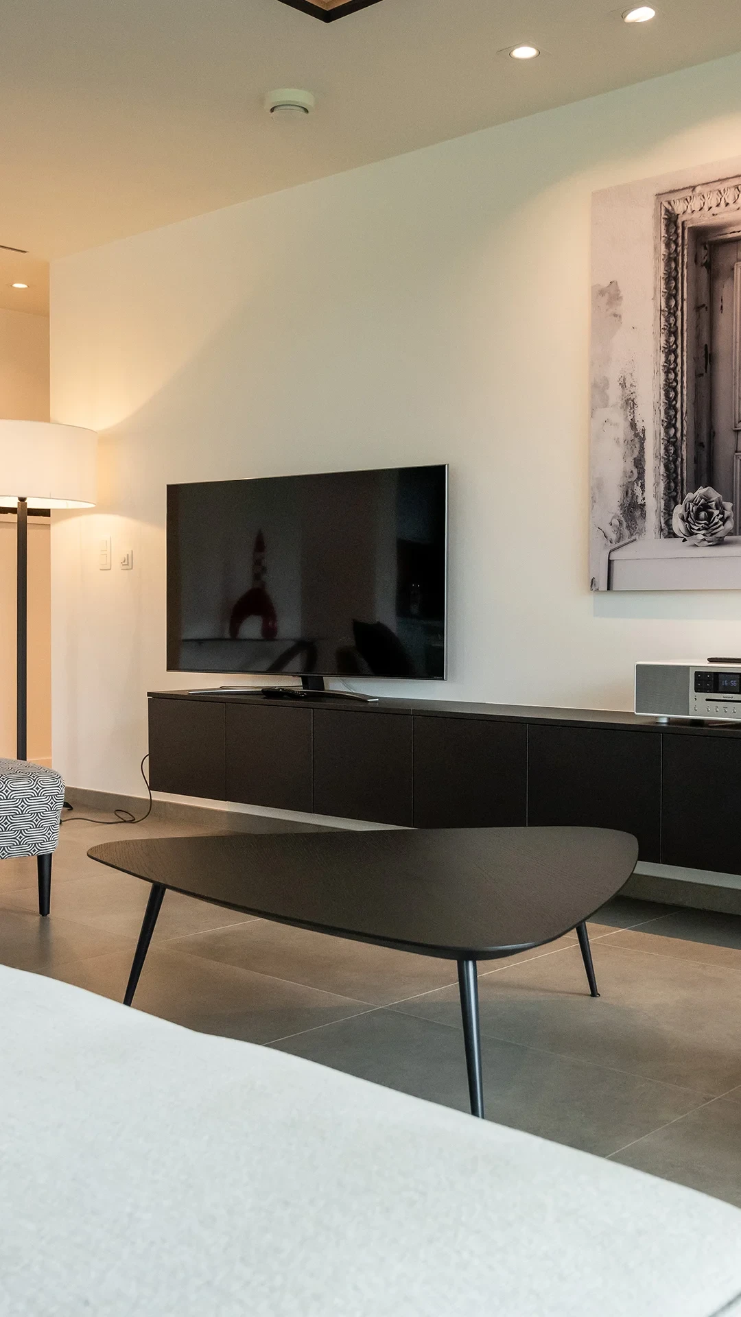 Salon moderne avec télévision et tableau décoratif.
