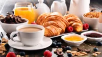 Petit-déjeuner avec croissants et café sur table.