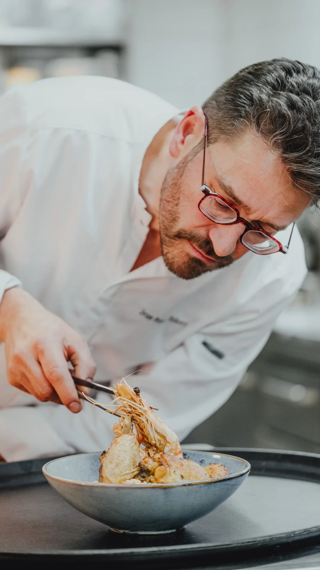 Chef préparant un plat gourmet dans la cuisine.