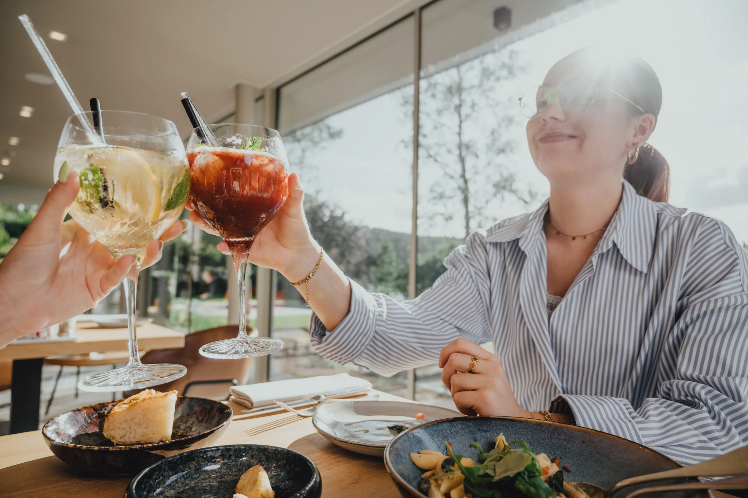 Amis trinquent avec des cocktails au restaurant lumineux - Séminaire Ardennes - Robert Hôtels